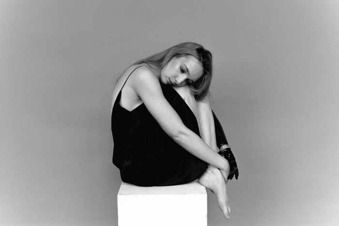 woman sitting while looking lonely